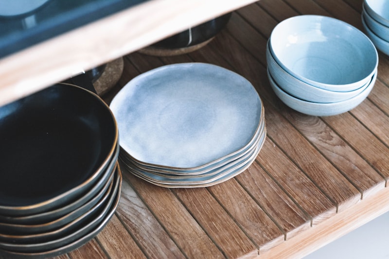 Assiettes et bols en porcelaine sur une étagère en bois